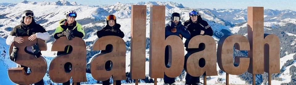 Jugendliche posieren mit einer Skulptur in Saalbach
